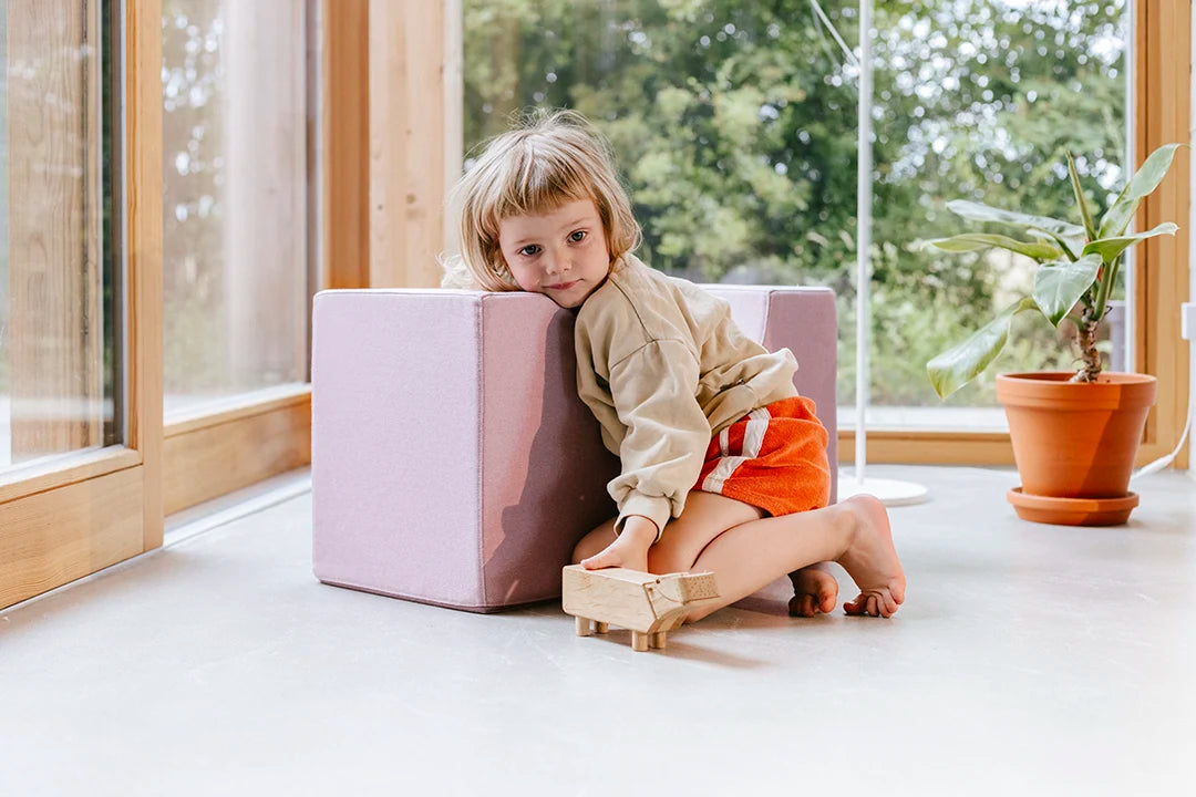 Kind lehnt sich spielend an die Present Stories Softbausteine Brücke – stabiler XXL Schaumstoff Baustein in Brückenform, ideal für fantasievolles Spielen, Softplay und kreative Bauideen im Kinderzimmer.