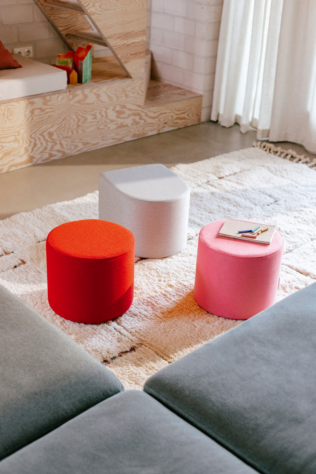 Drei bunte Present Stories Softbausteine in Hockerform – vielseitige XXL Schaumstoff Bausteine für Softplay, Sitzmöbel, kreative Spiele und flexible Kinderzimmer Einrichtung.