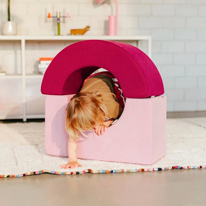 Kind krabbelt durch eine Spielhöhle aus Present Stories Softbausteinen – Kombination aus Brücke und Bogen als XXL Schaumstoff Bausteine für kreatives Softplay, Bauen und fantasievolles Spielen im Kinderzimmer.