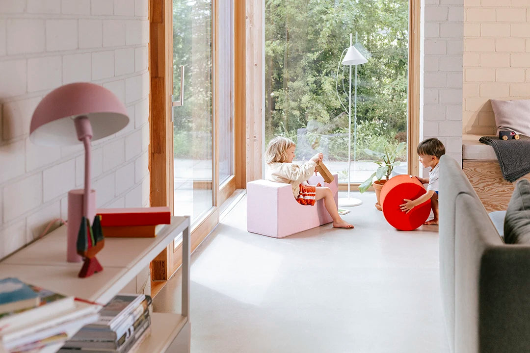 Zwei Kinder spielen im hellen Wohnzimmer mit Present Stories Softbausteinen – bunte XXL Bausteine aus Schaumstoff für kreatives Softplay und sicheres Spielen im Kinderzimmer.