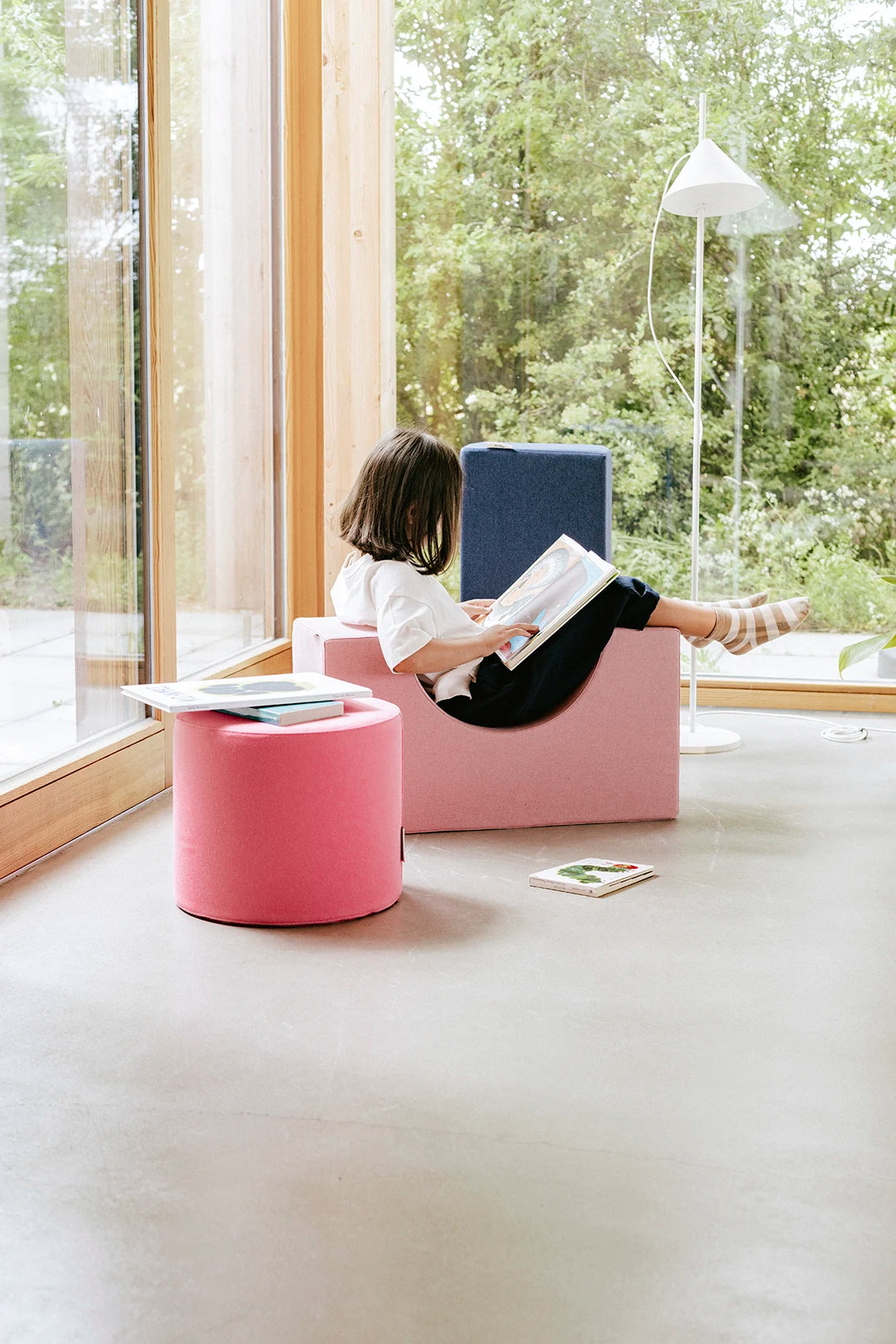 Kind entspannt beim Lesen auf Present Stories Softbausteinen – multifunktionale XXL Bausteine aus Schaumstoff für kreatives Softplay, Spielen und gemütliches Sitzen im Kinderzimmer.