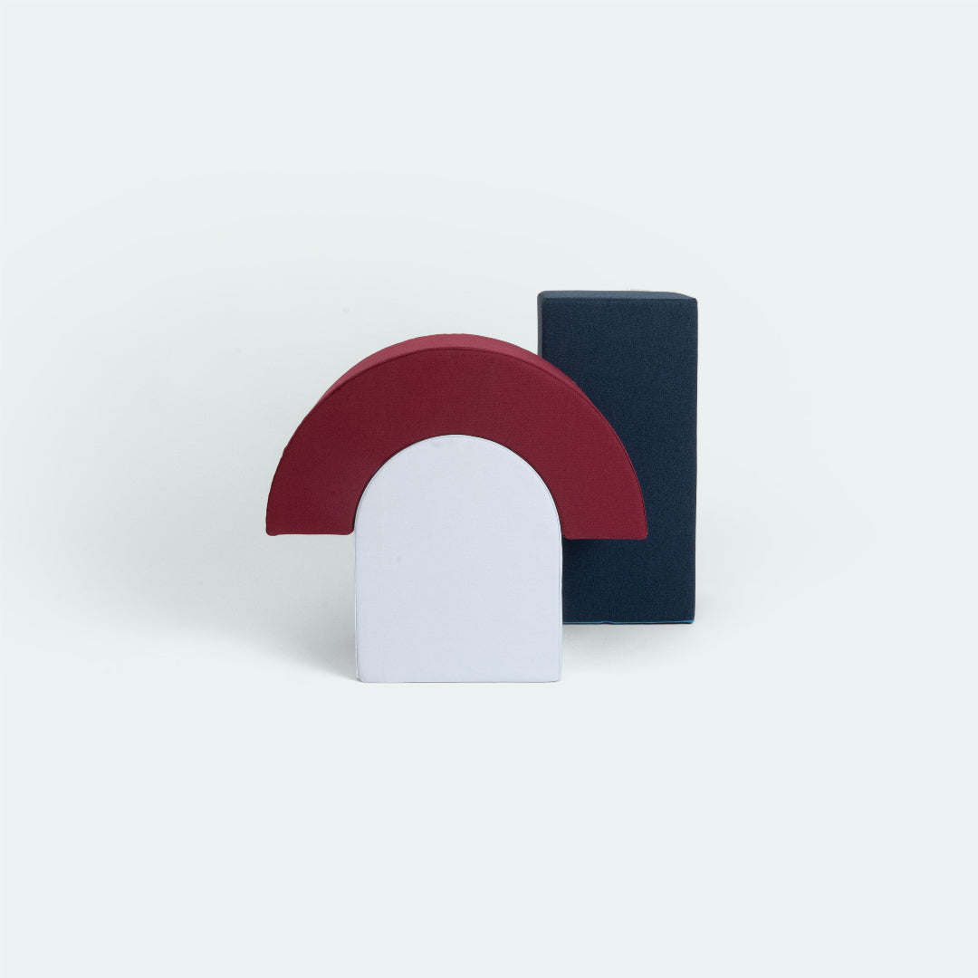 Freigestelltes Set aus Ramba (Wippe in Berry) und Zamba (Hocker in Stone) mit dunkelblauer Bank von Present Stories.