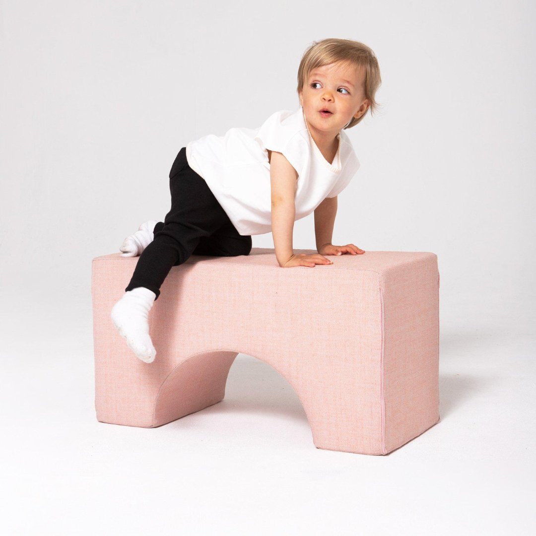 Kleinkind klettert auf der Present Stories Softbausteine Brücke – stabiler XXL Schaumstoff Baustein in Brückenform, ideal für Softplay, Motorikförderung und fantasievolles Spielen im Kinderzimmer.